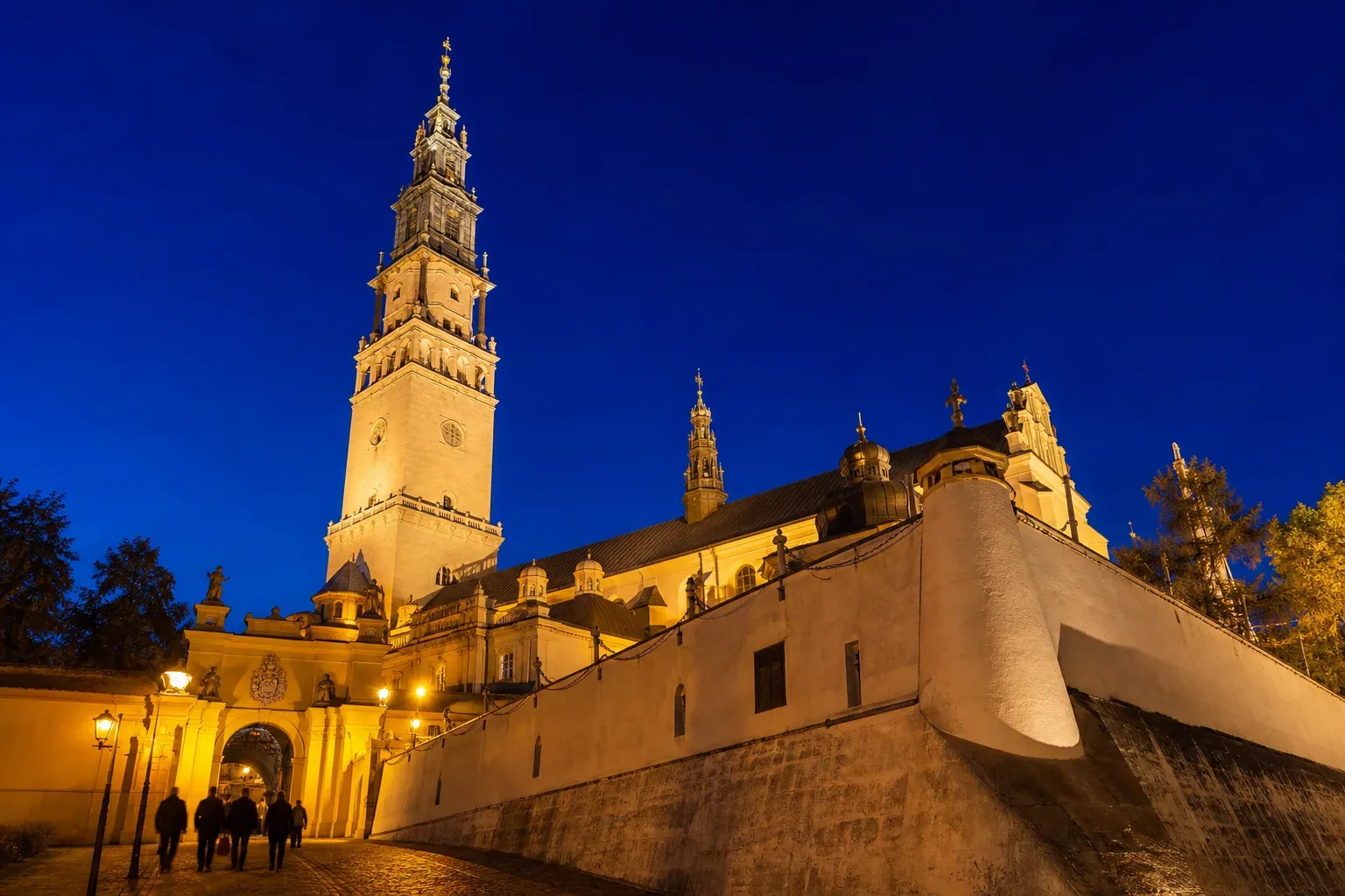 The bell tower and fortress walls of the Jasna Góra Monastery in Częstochowa, floodlit at dusk